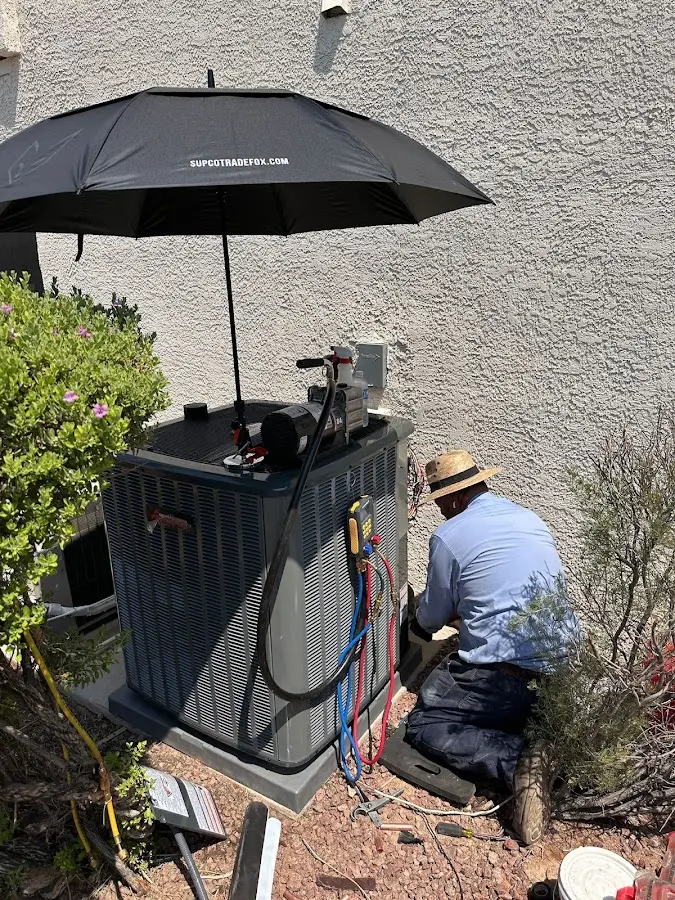 HVAC technician performing outdoor AC maintenance in Danville